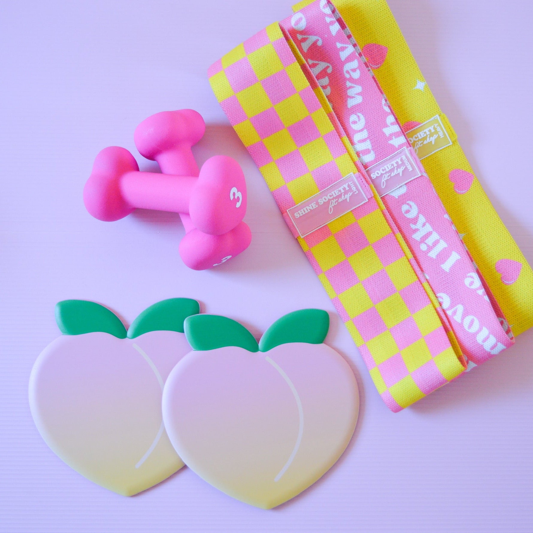3 hip resistance bands, 2 peach shaped sliding disks, a set of 3 pound heart shaped weights