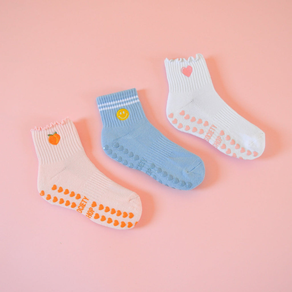 Three pairs of colorful socks on a pink background