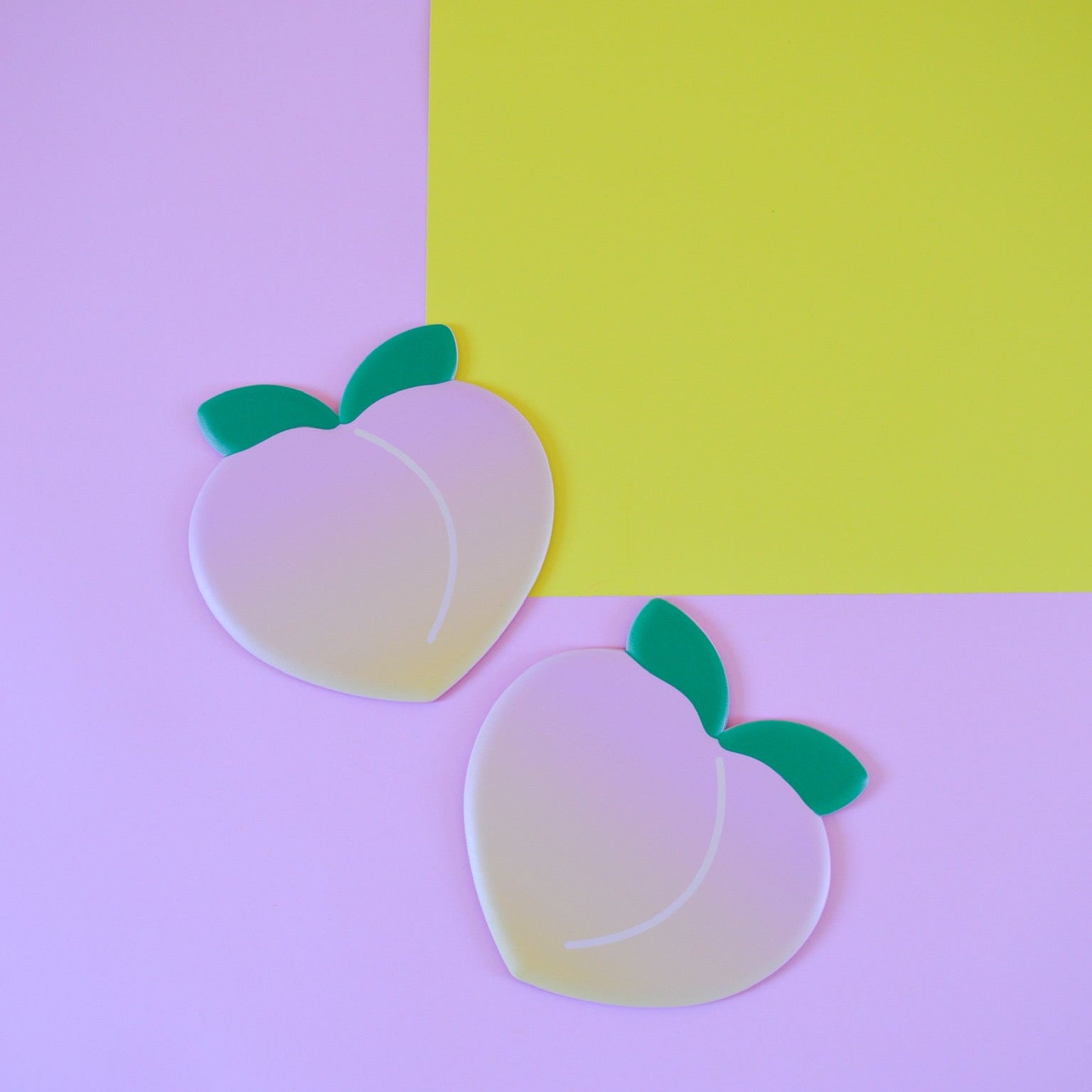 Two peach-shaped sliding disks on a two-tone pink and yellow background