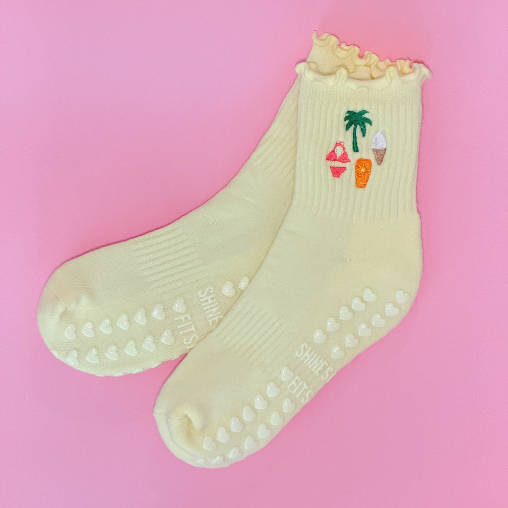 Yellow socks with a palm tree and ice cream design on a pink background