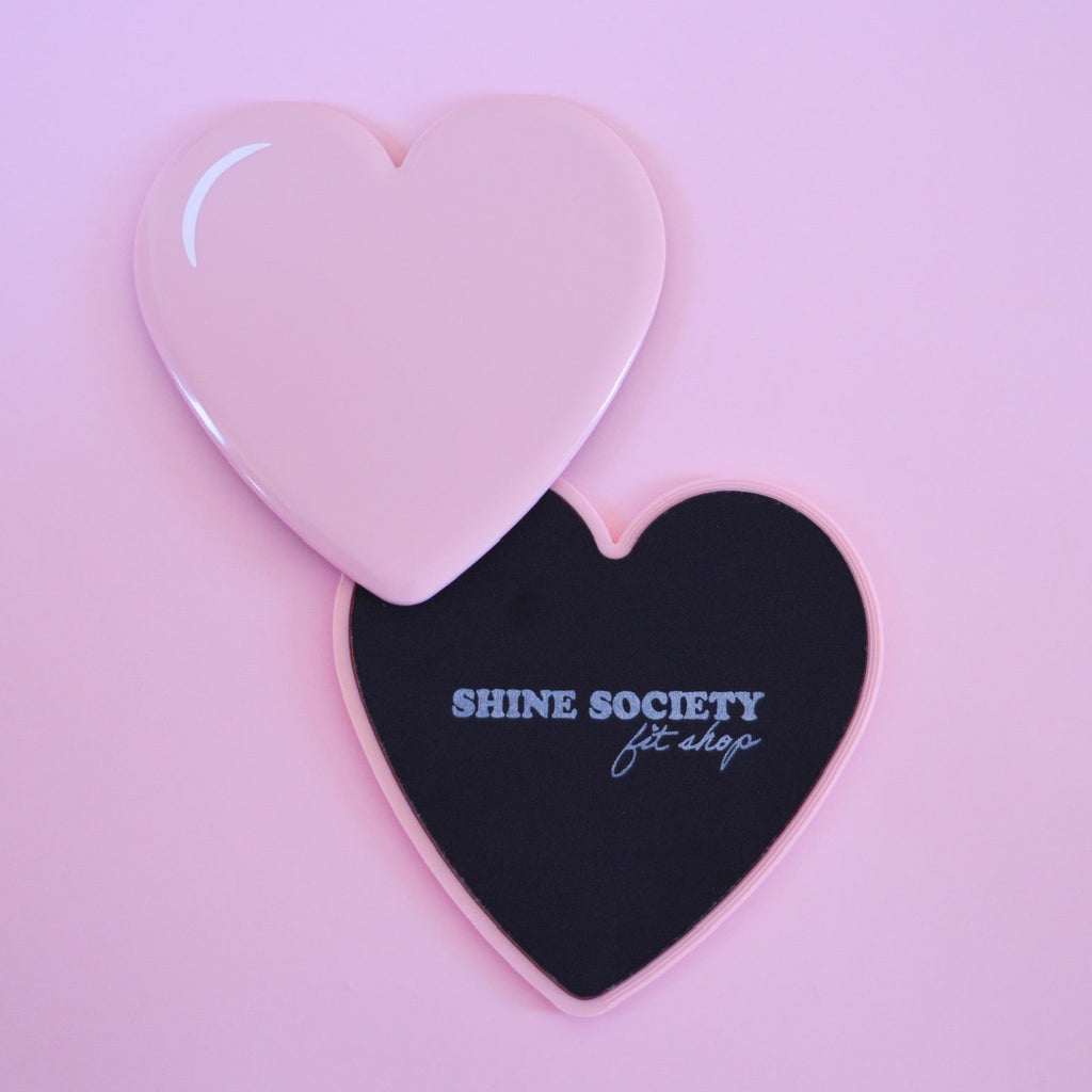 Heart-shaped sliding disks with 'Shine Society' branding on a pink background
