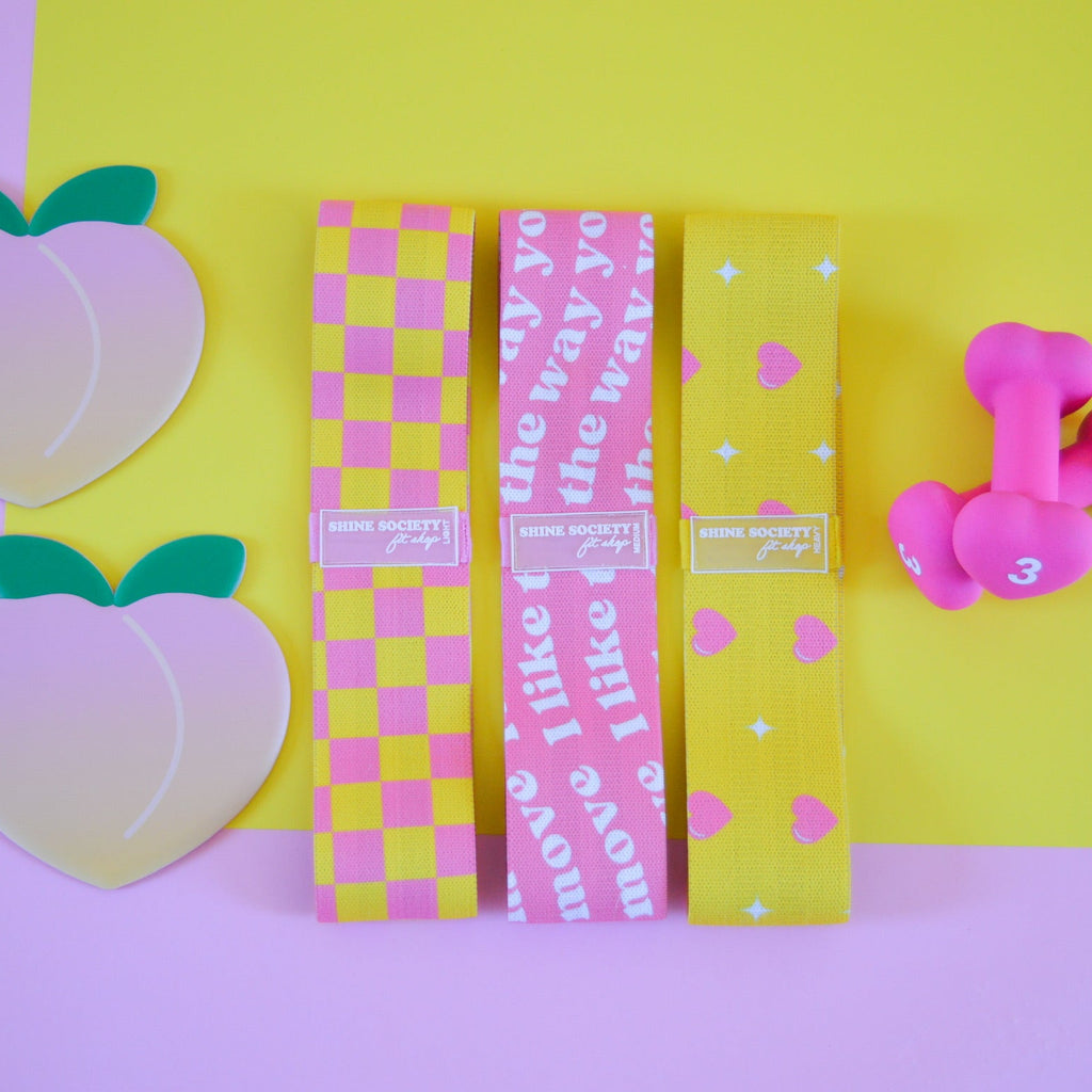 3 hip resistance bands, 2 peach shaped sliding disks, a set of 3 pound heart shaped weights