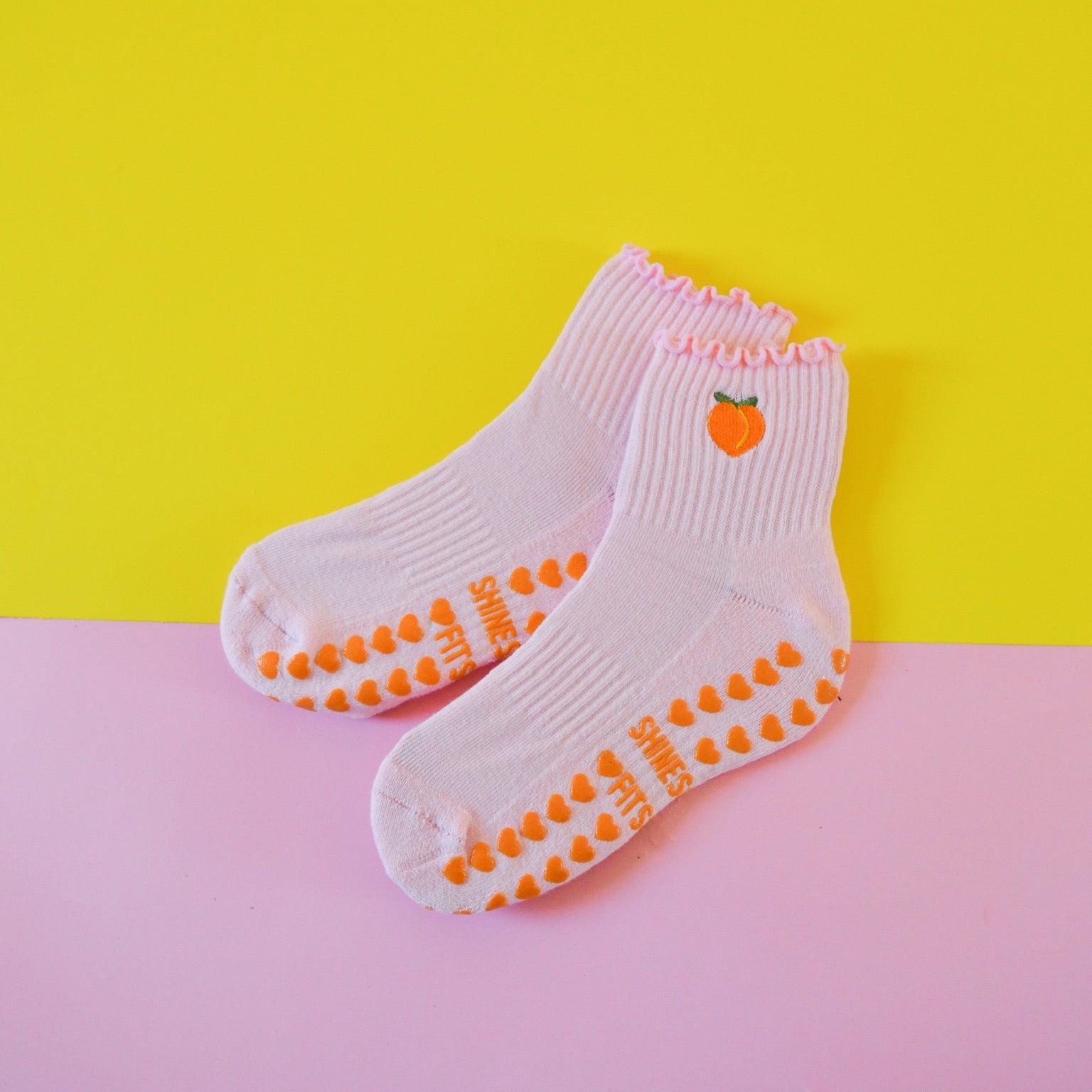 Grip socks with peach on yellow and pink background