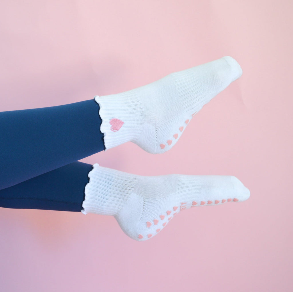 White socks with heart patterns on a pink background