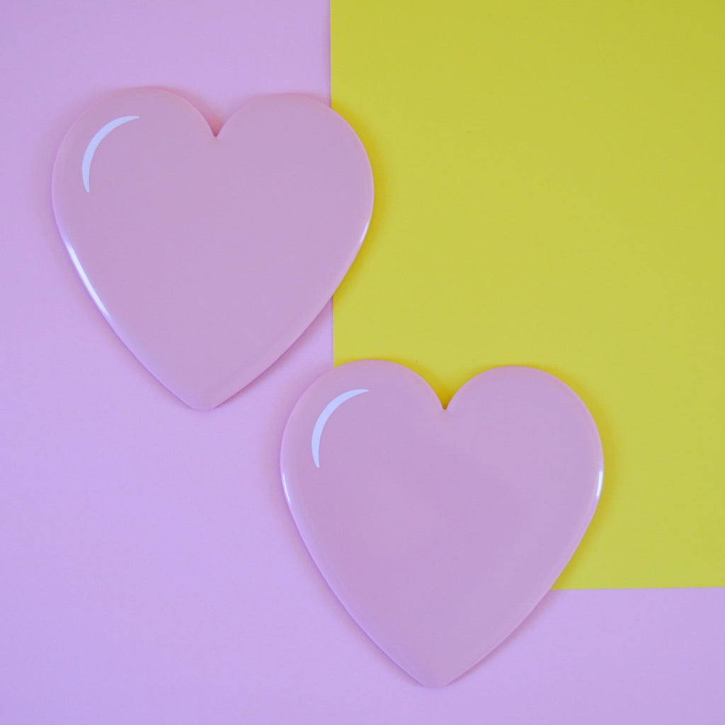 Two pink heart-shaped sliding disks on a split pink and yellow background