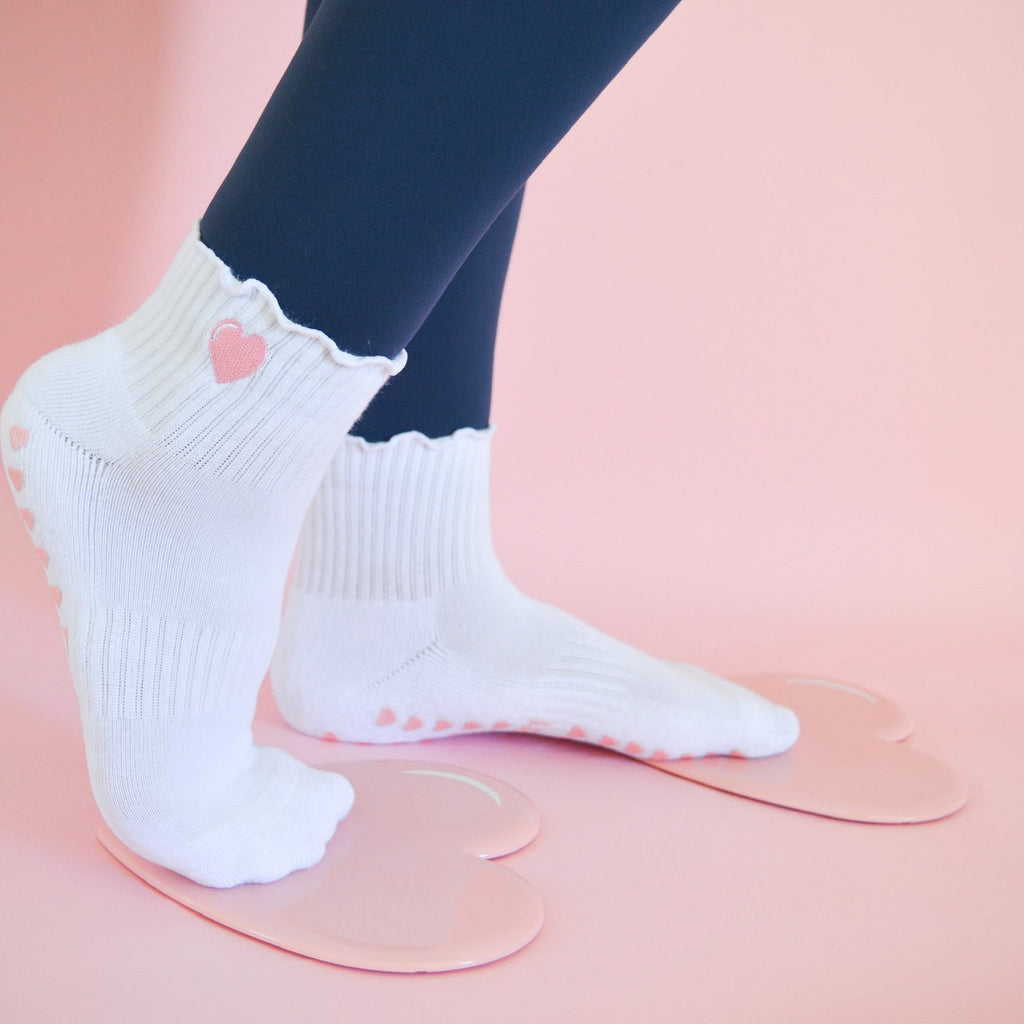 White socks with pink hearts worn with heart sliding disks