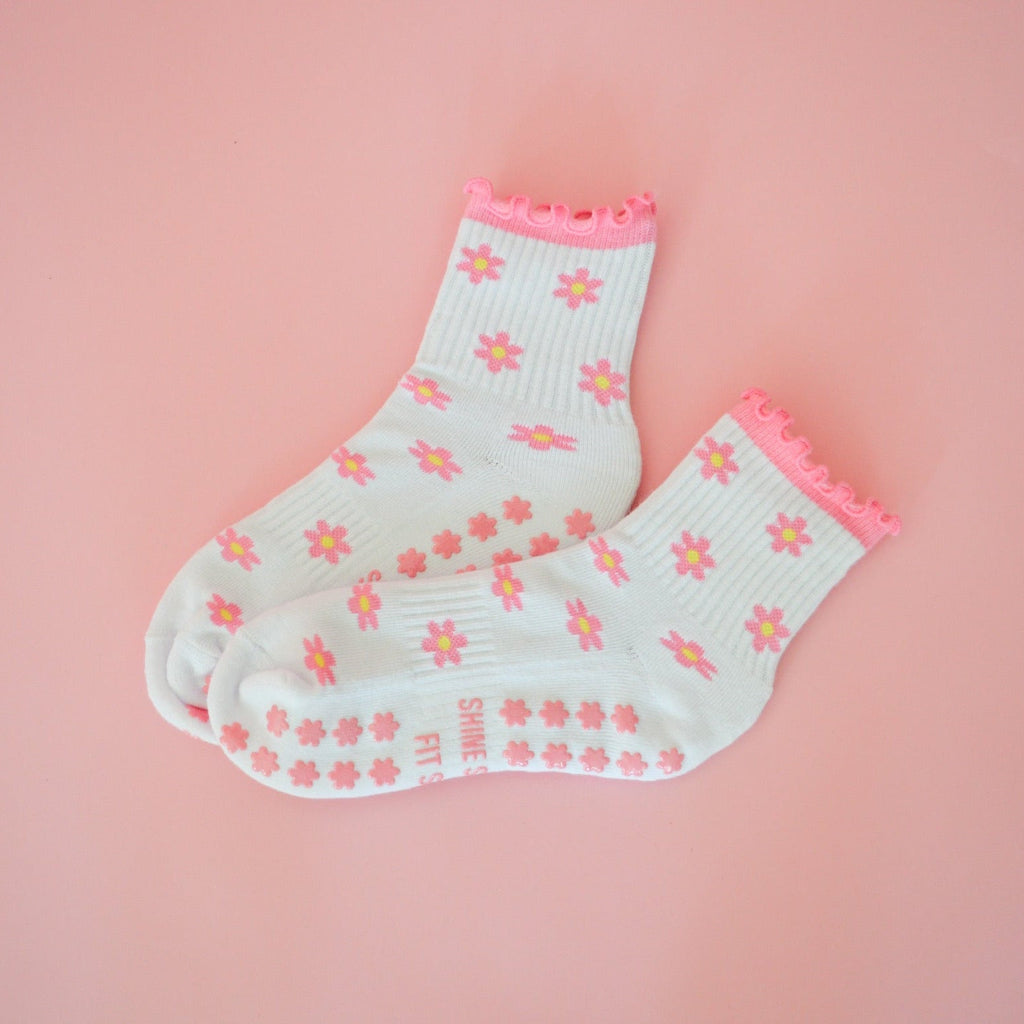 White sock with pink floral pattern on a pink background