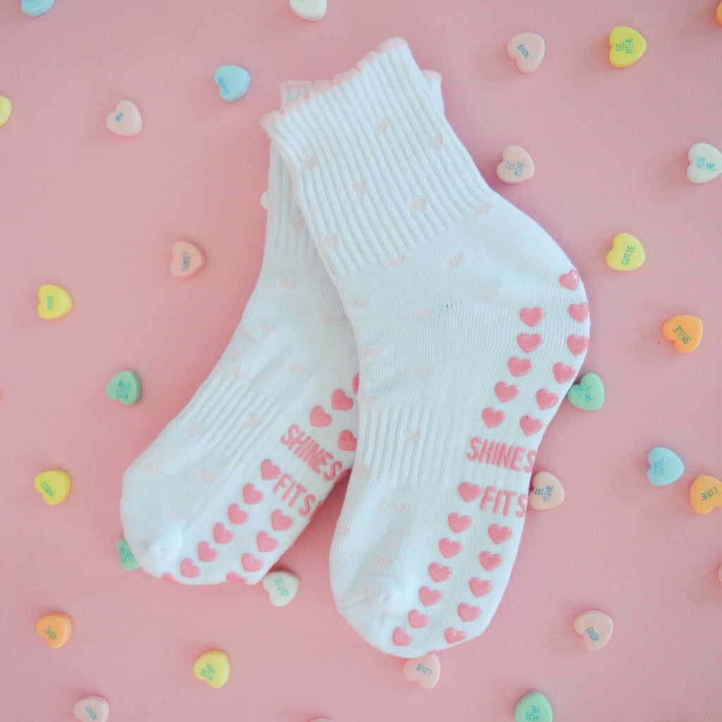 white grip socks with light pink hearts and heart grips, pilates grip socks