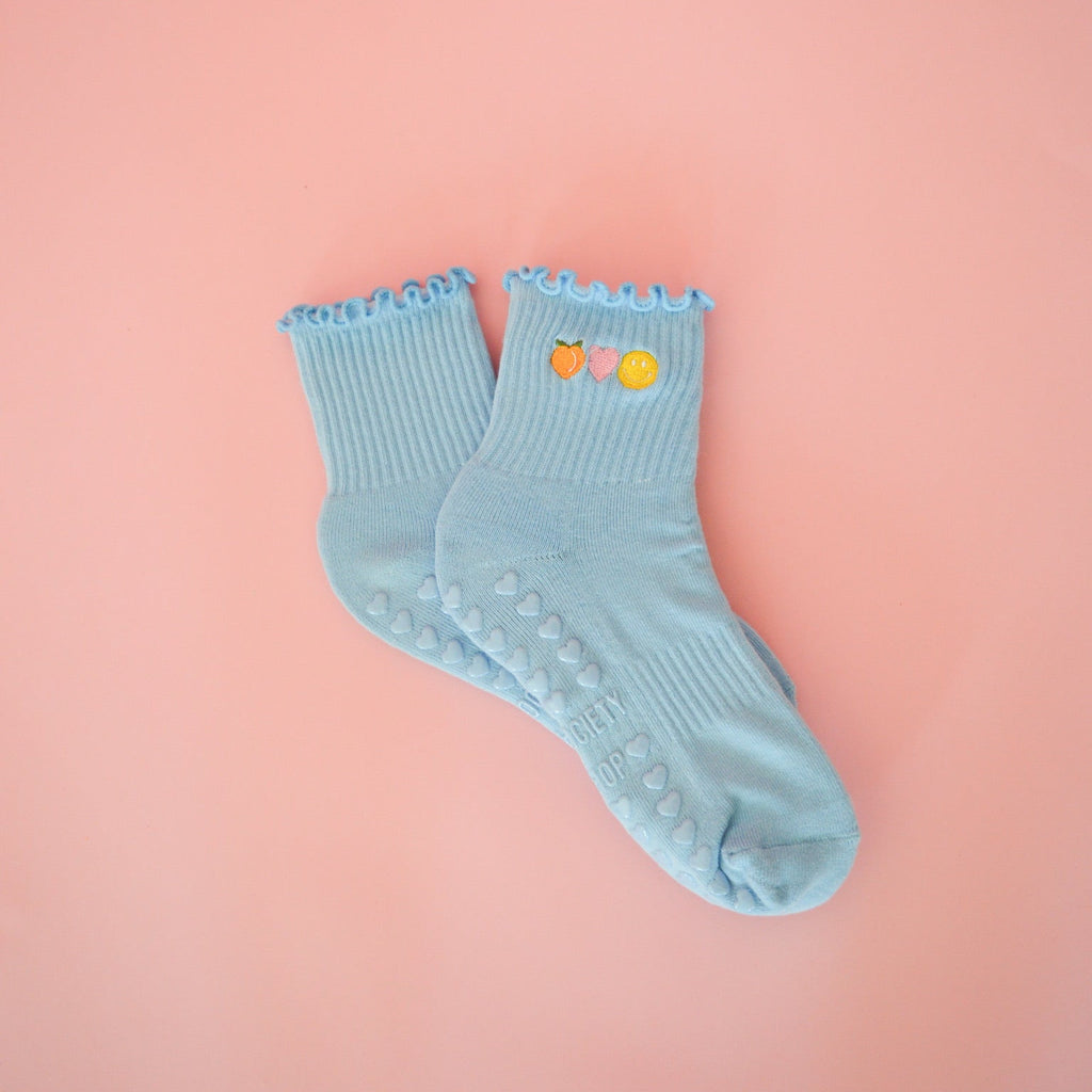 Light blue socks with colorful accents on a pink background