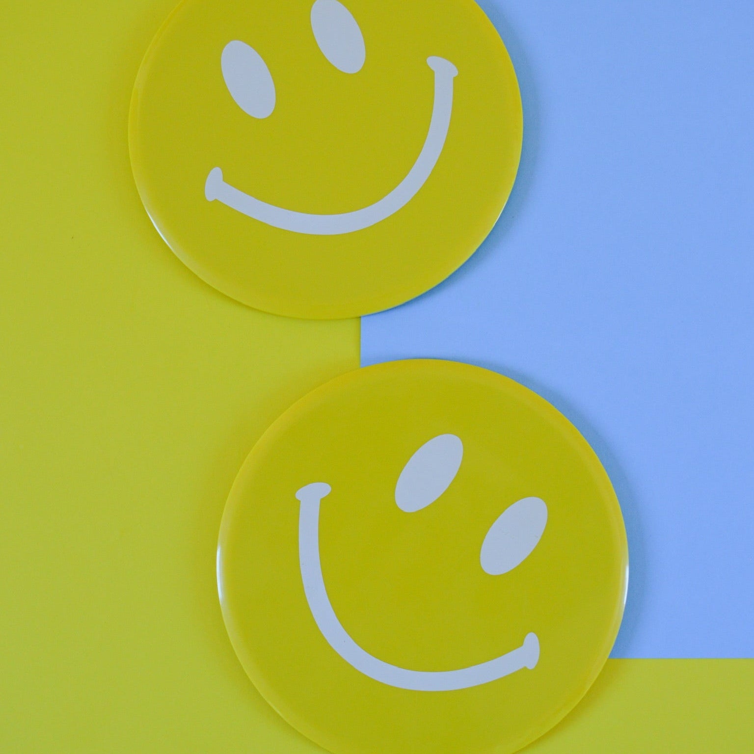 Two yellow smiley face sliding disks on a yellow and blue background
