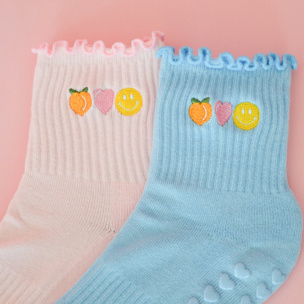 Pink and Blue sock with colorful peach happy face and heart on a pink background